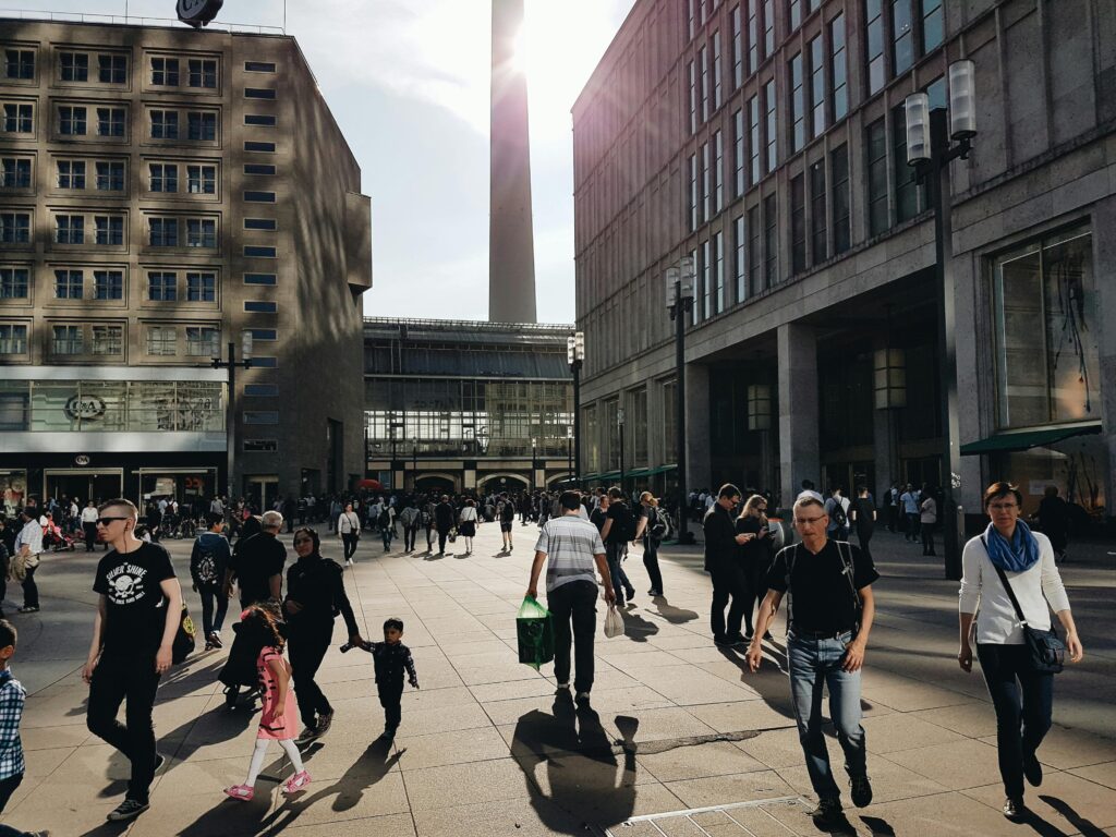 A busy shopping street in Berlin with pedestrians enjoying a sunny day in the city center.